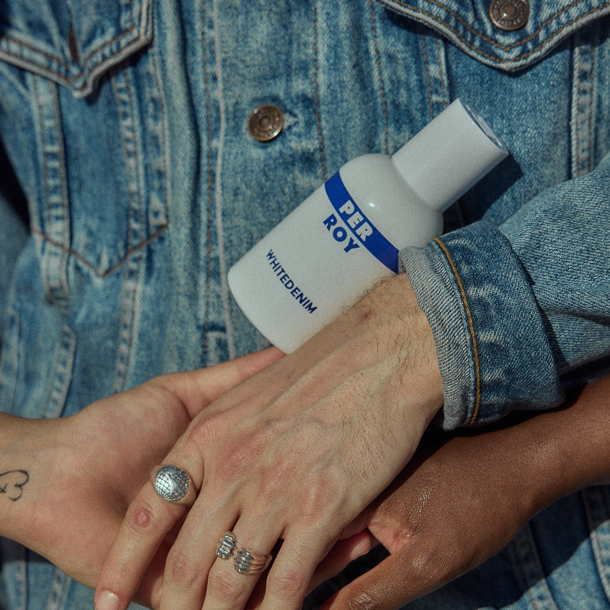 Perroy White Denim lifestyle — parfumfles in spijkerjasje, zout en melkig akkoord